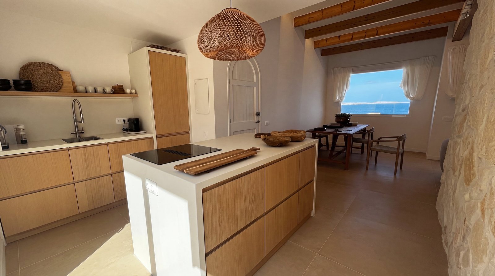 Cocina abierta con vistas al mar reformada por Reform Complet en Arenal d'en Castell, Menorca