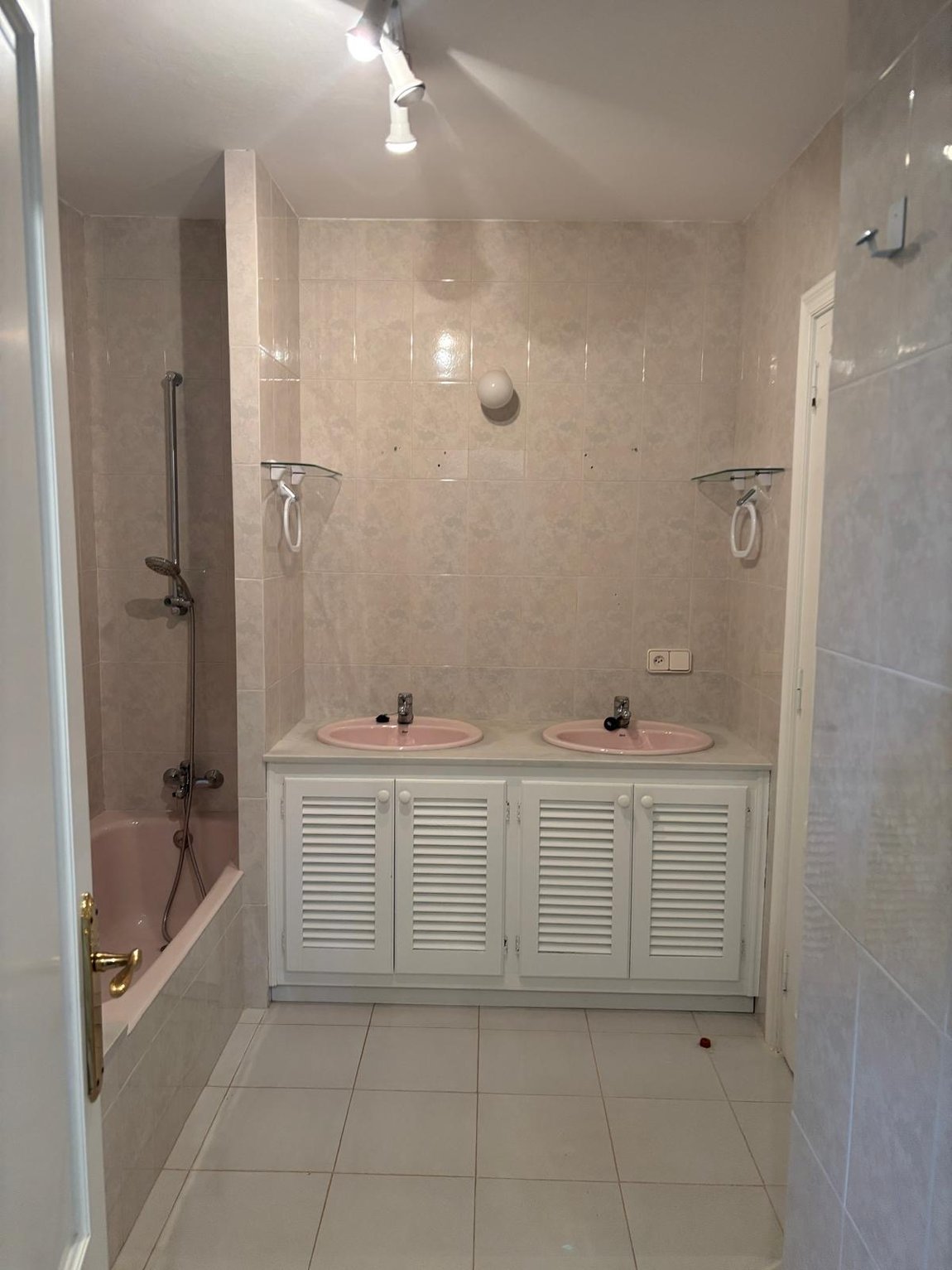 Baño principal antes de la reforma, con bañera y doble lavabo en rosa