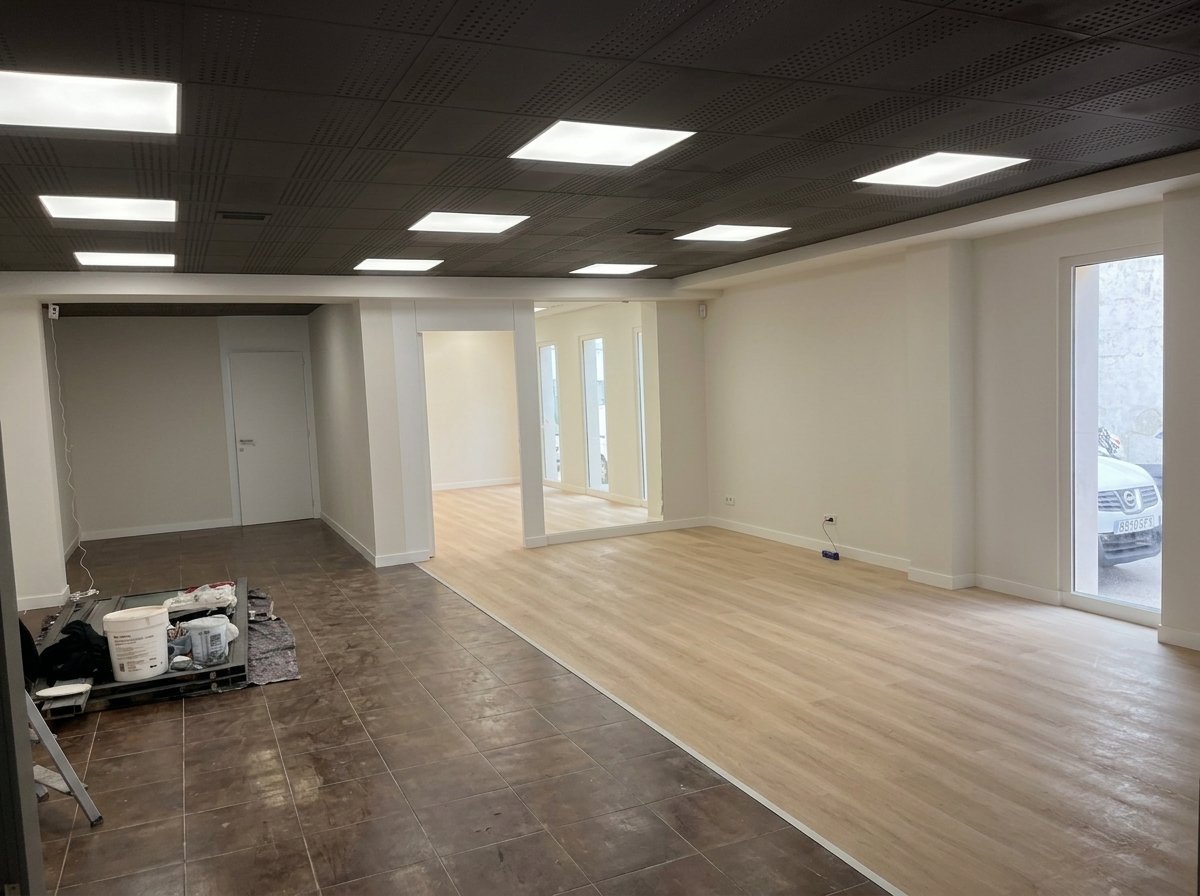 Instalación de parquet en local comercial junto al suelo de baldosa anterior, en obra