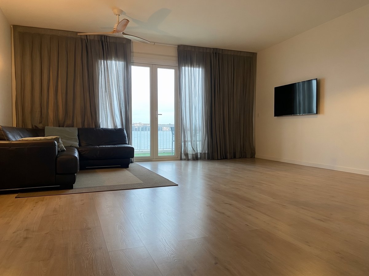 Salón con suelo de parquet instalado y vistas al mar, acabado final