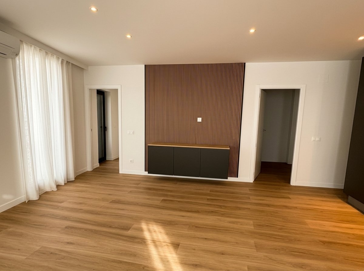 Salón con panel de acento en el piso reformado de Mahón